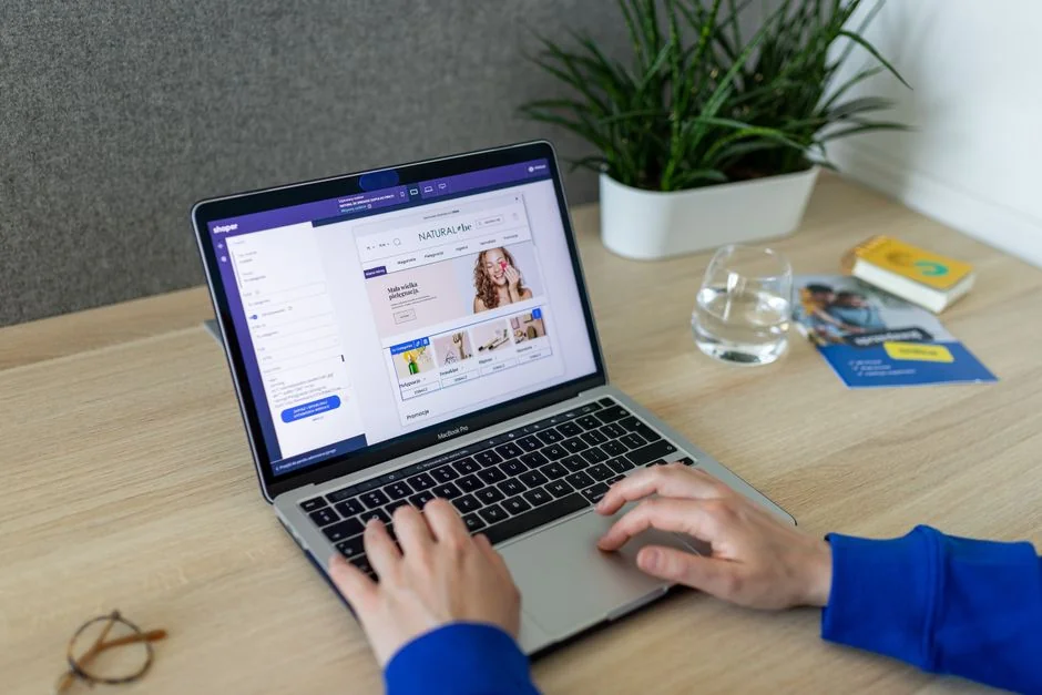 A website wireframe on a macbook screen on an office desk.